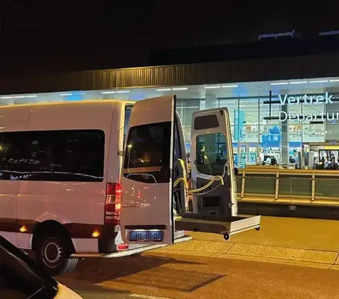 Rolstoelbus met lift bij de vertrekhal van Schiphol